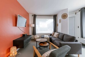 Relax in this stylish living room with a flat-screen TV, comfortable sofa, and cozy coffee table.