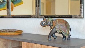 Una estatua decorativa de elefante sobre una encimera, con una cesta tejida a su lado.