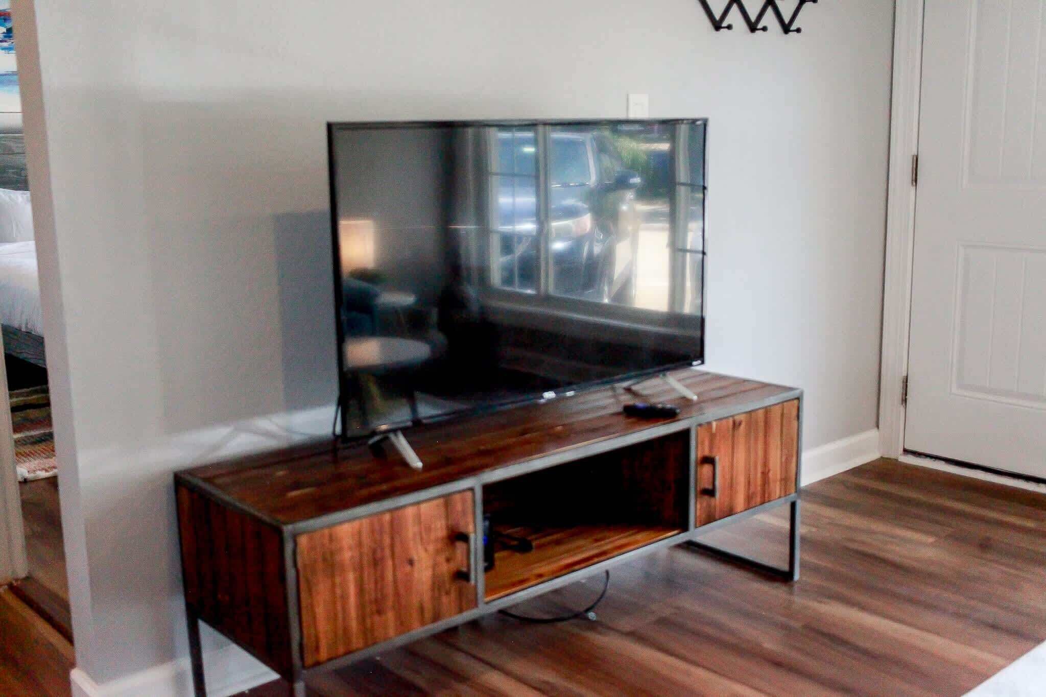 Un mueble de madera para entretenimiento con un televisor de pantalla plana montado encima.