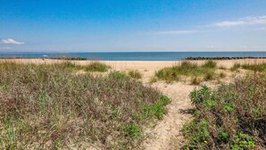 A beach with a clear sky, sandy dunes, and a calm sea. - Sojourn Beach Suite 2 BR 2 BA at Beach Cottages (Norfolk)