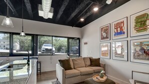 Un interior moderno con zona de cocina, sofá y mesa de comedor.