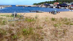 A beach with a pier extending into the water, surrounded by houses and boats. - 4 bedroom lovely home in Njurunda (Njurunda)