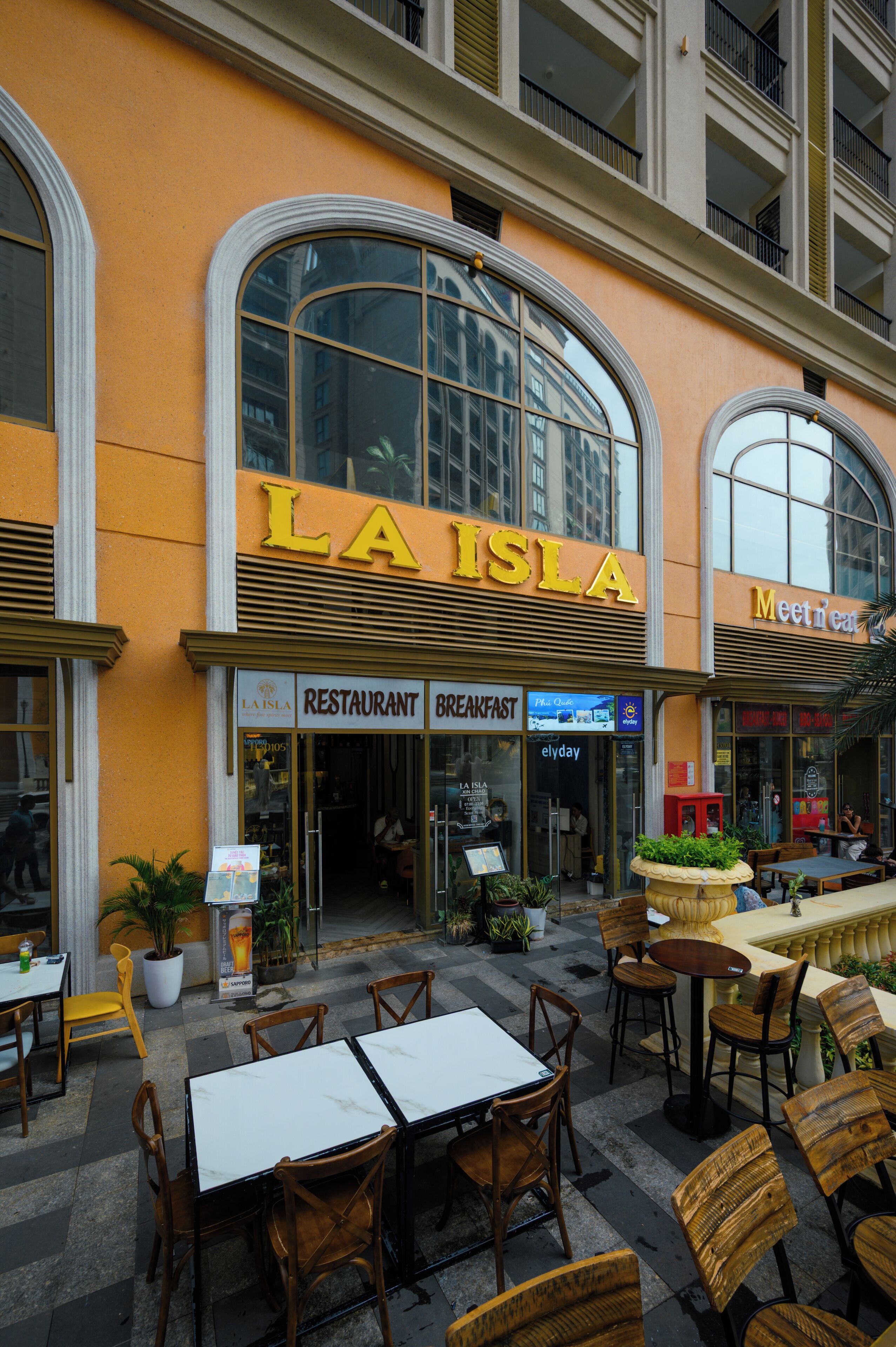 A restaurant named 'LA ISLA' with outdoor seating and a view of the city.