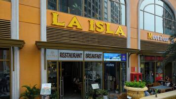 A restaurant named 'LA ISLA' with outdoor seating and a view of the city.