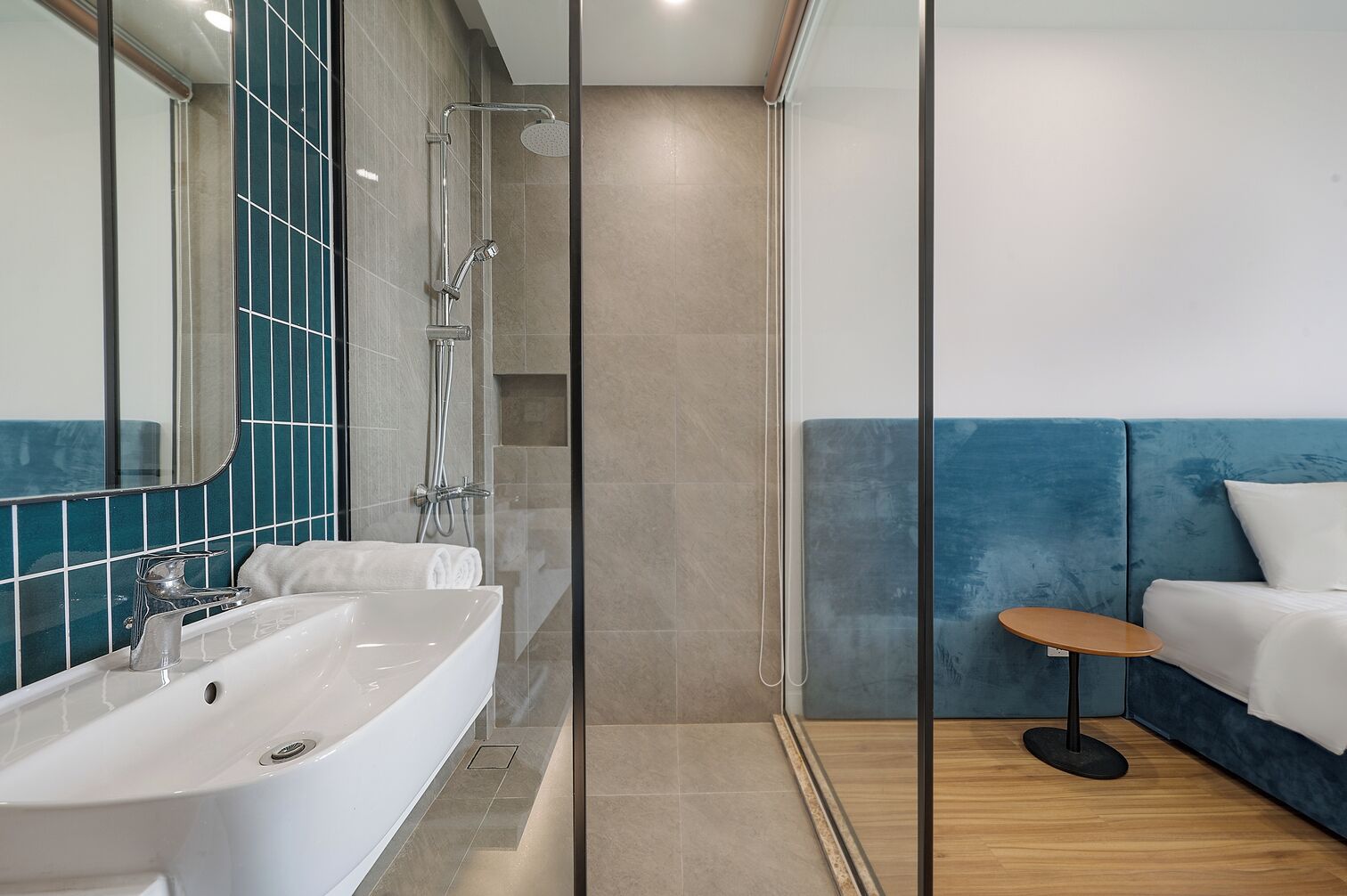 A modern bathroom with a bathtub, shower, and a glass partition.