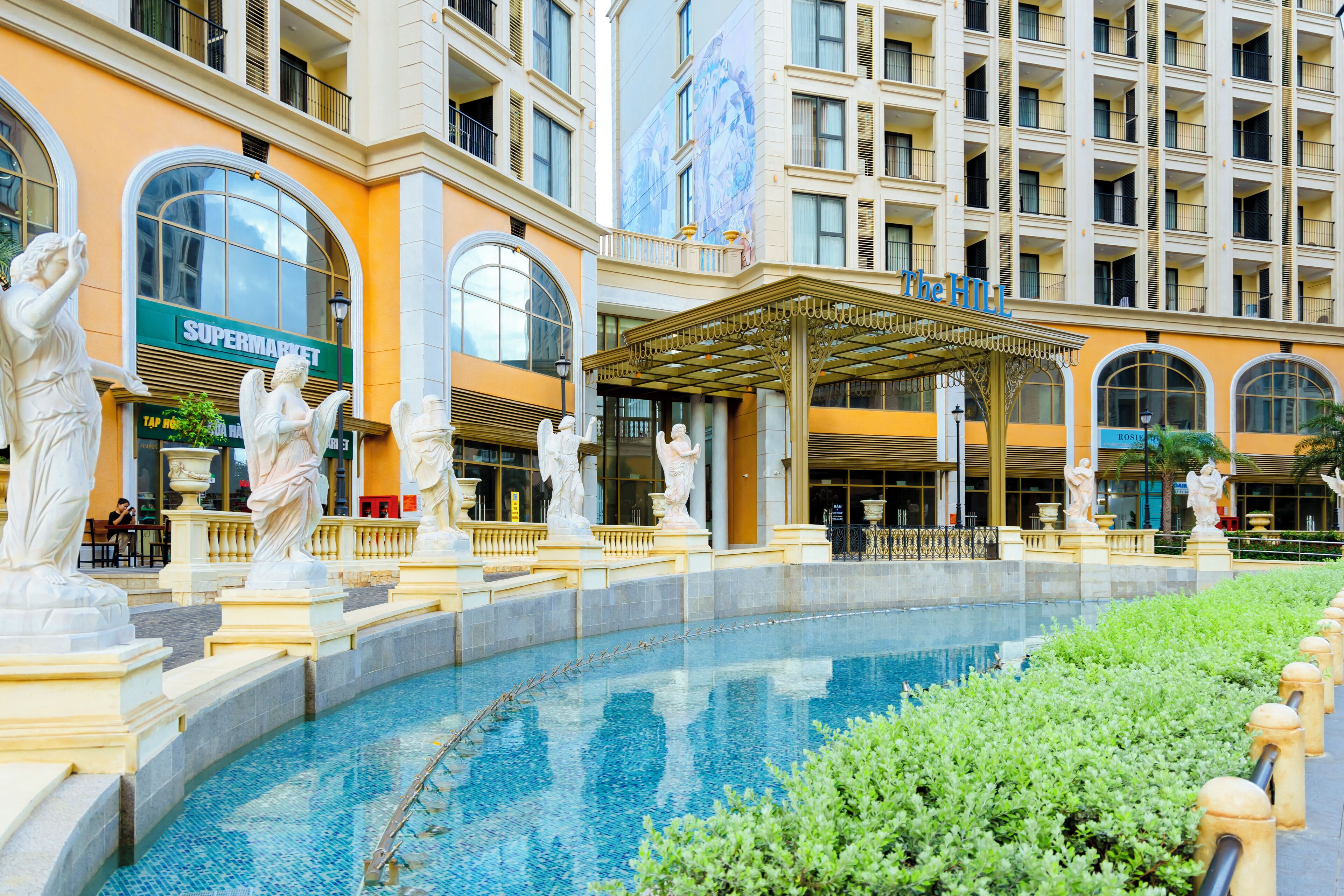 Un hôtel doté d’une piscine, de statues et d’un supermarché.