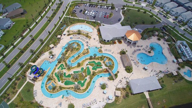 An aerial view of a resort with multiple swimming pools, a golf course, and a parking area. - 6BD Storey Lake Pool Home with Resort Amenities near DISNEY (Kissimmee)
