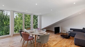 Un interior moderno con una mesa de comedor, sillas, un sofá y un televisor.