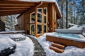 A wooden cabin with a hot tub, surrounded by snow and trees. - Ramshorn Basecamp, Hot Tub, Arcade, Higher-end (Truckee)