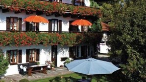 A multi-story building with balconies, outdoor seating, and potted plants.