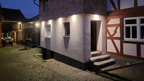 Een gebouw met twee verdiepingen, een kinderafdeling, een garage en een zichtbare trap naar de ingang.