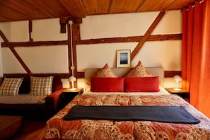 A room with a bed, a sofa, wooden beams, and a picture on the wall. - Apartment 'Inselgasse' with Wi-Fi (Konstanz)