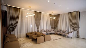 Un salon moderne avec un canapé, des fauteuils et un tapis.