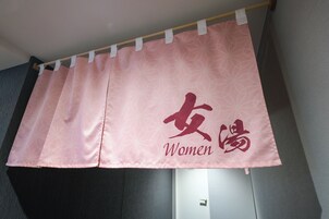 A pink curtain with "Women" and Chinese characters.