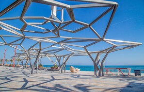 Una estructura metálica geométrica con vistas despejadas al océano y un sendero adoquinado.