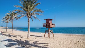 Ein Strand mit Palmen und einem Rettungsturm.