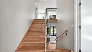 Una escala moderna de fusta que condueix a un segon pis.