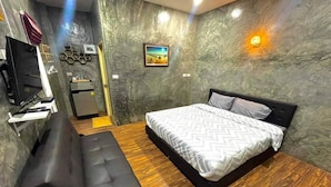 Ein modernes Schlafzimmer mit Bett, einer Sitzbank, einem Schreibtisch und einem Fernseher.