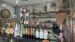 Eine Bar mit einer Auswahl an Flaschen und einer Uhr an der Wand.