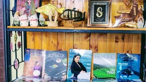 A shelf with various items including figurines, books, and a framed picture. - V House (Ayutthaya)