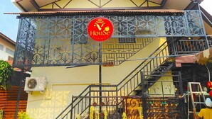 A building with a sign reading "House" and a staircase with decorative railings. - V House (Ayutthaya)