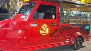 A red pickup truck with a logo on the side. - V House (Ayutthaya)