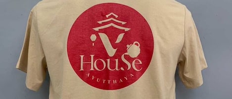 A mannequin wearing a beige t-shirt with a red logo and text on the back.