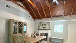 A dining area with a wooden table and chairs, a cabinet, and a fireplace. - Cozy Waterfront Retreat at McMichael Farms (Chesterfield)