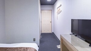 A hotel room with a bed, a TV, a door, and a hallway. - Tabist Takamatsu Pearl Hotel (Takamatsu)