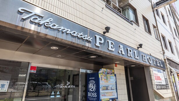 The exterior of the Takamatsu Pearl Hotel with a clear sign, a coffee vending machine, and a visible entrance. - Tabist Takamatsu Pearl Hotel (Takamatsu)