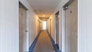 A hotel hallway with white doors numbered 306 and 310, carpeted floor, and a ceiling with recessed lighting. - Tabist Takamatsu Pearl Hotel (Takamatsu)