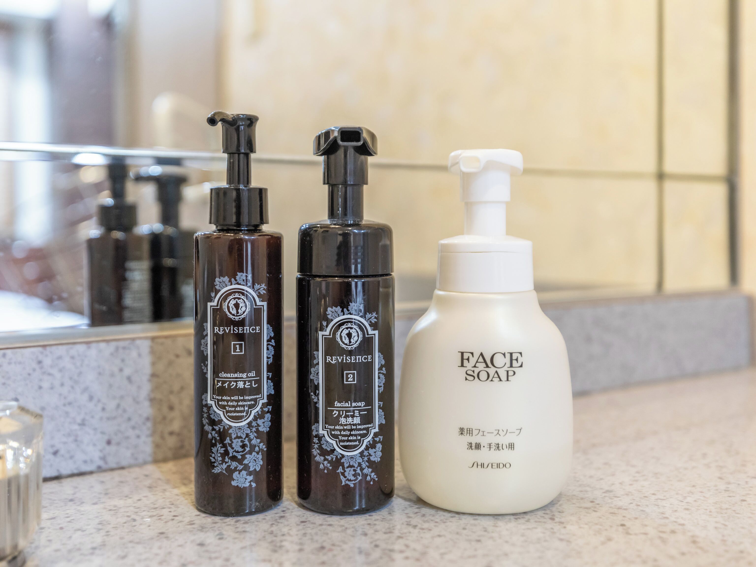 Three skincare bottles on a countertop.