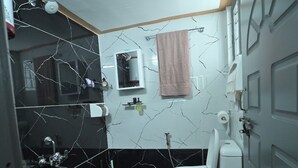 Une salle de bain avec des toilettes, un lavabo et un miroir.