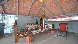 Un vaste espace intérieur doté d’un haut plafond, de meubles en bois et d’un fauteuil rouge.