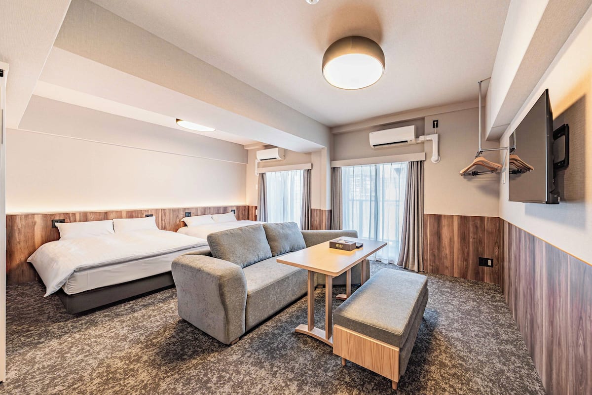 Une chambre d’hôtel avec un lit, un canapé, une table et une télévision.