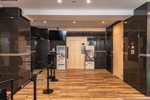 A modern hotel lobby with a check-in counter, a wooden floor, and glass walls. - Apartment Hotel 11 Dotonbori II (Osaka)