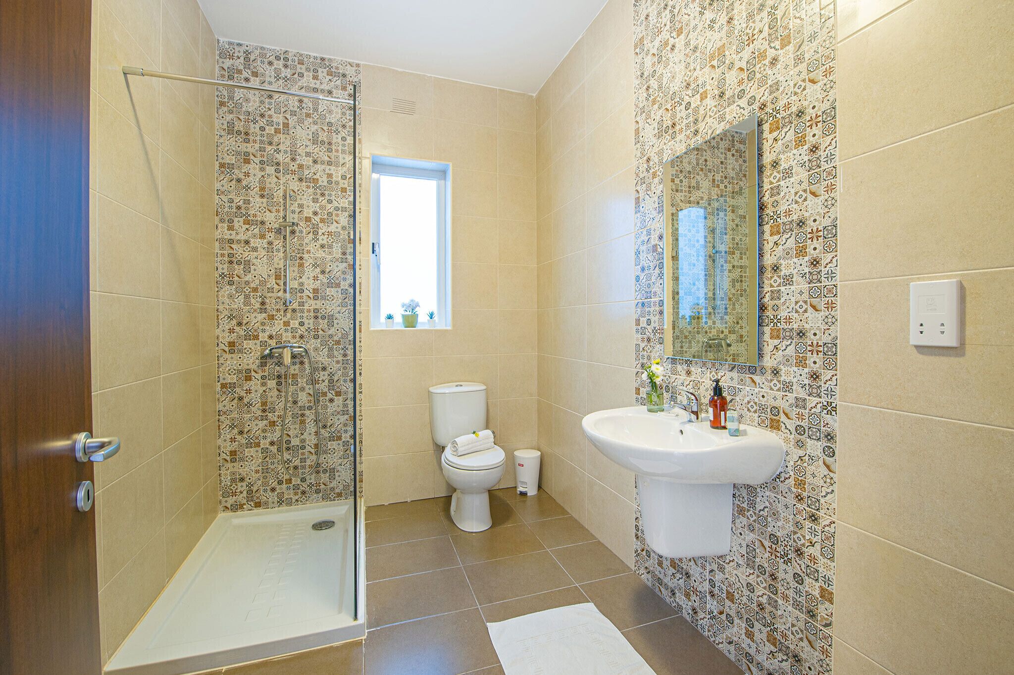 A bathroom with a shower, toilet, and sink.