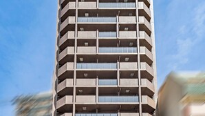 A multi-story building with a flat facade, balconies, and a sign indicating it is an apartment hotel. - Apartment Hotel 11 Namba Minami III (Osaka)