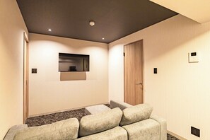 Ein modernes Interieur mit einer Couch, einer Holztür und einer deckenmontierten Leuchte.