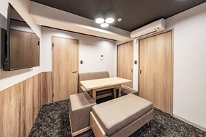 Una habitación pequeña con un armario de madera, una mesita y un banco.