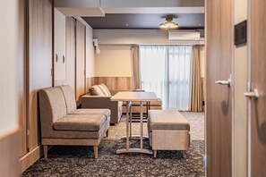 A hotel room with a sofa, a small table, and a bench. - Apartment Hotel 11 Shinsaibashi 4 (Osaka)