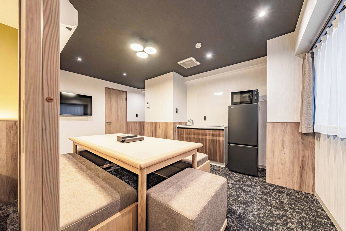 A compact kitchen with a dining area, a built-in microwave, and a refrigerator.