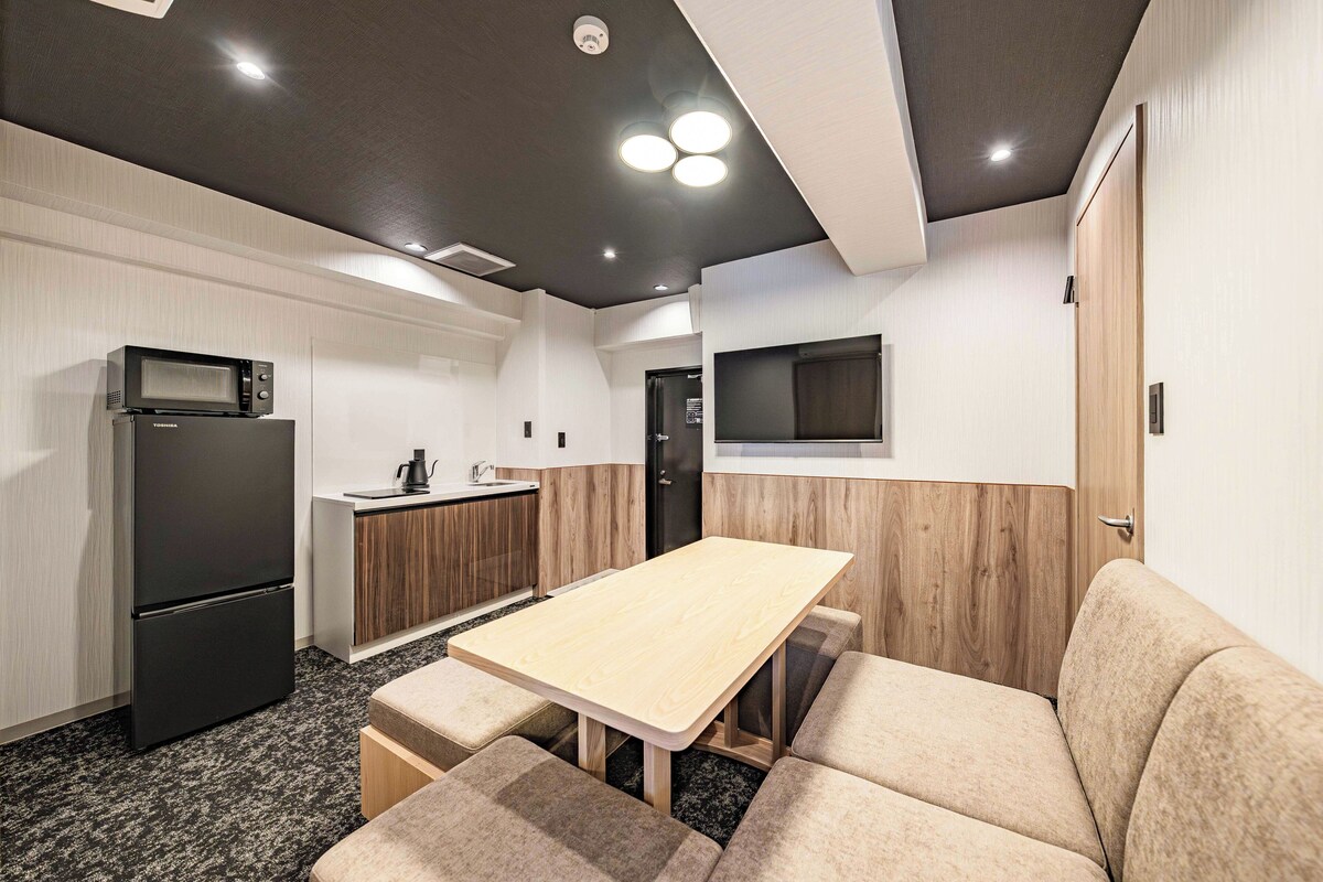 A compact kitchen with a microwave, refrigerator, and a small sink.