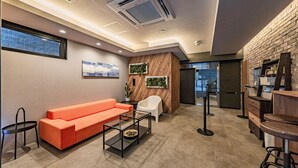 A modern interior with a sofa, chairs, a coffee table, and a bar area. - Apartment Hotel 11 Namba Minami Shin-Imamiya (Osaka)