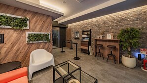 A modern interior with a wooden wall, a brick wall, a glass table, and a potted plant. - Apartment Hotel 11 Namba Minami Shin-Imamiya (Osaka)