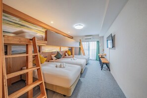 Een hotelkamer met stapelbedden, een bureau en een televisie.