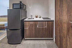 Une cuisine de taille réduite, équipée d’un réfrigérateur, d’un évier et d’un plan de travail.