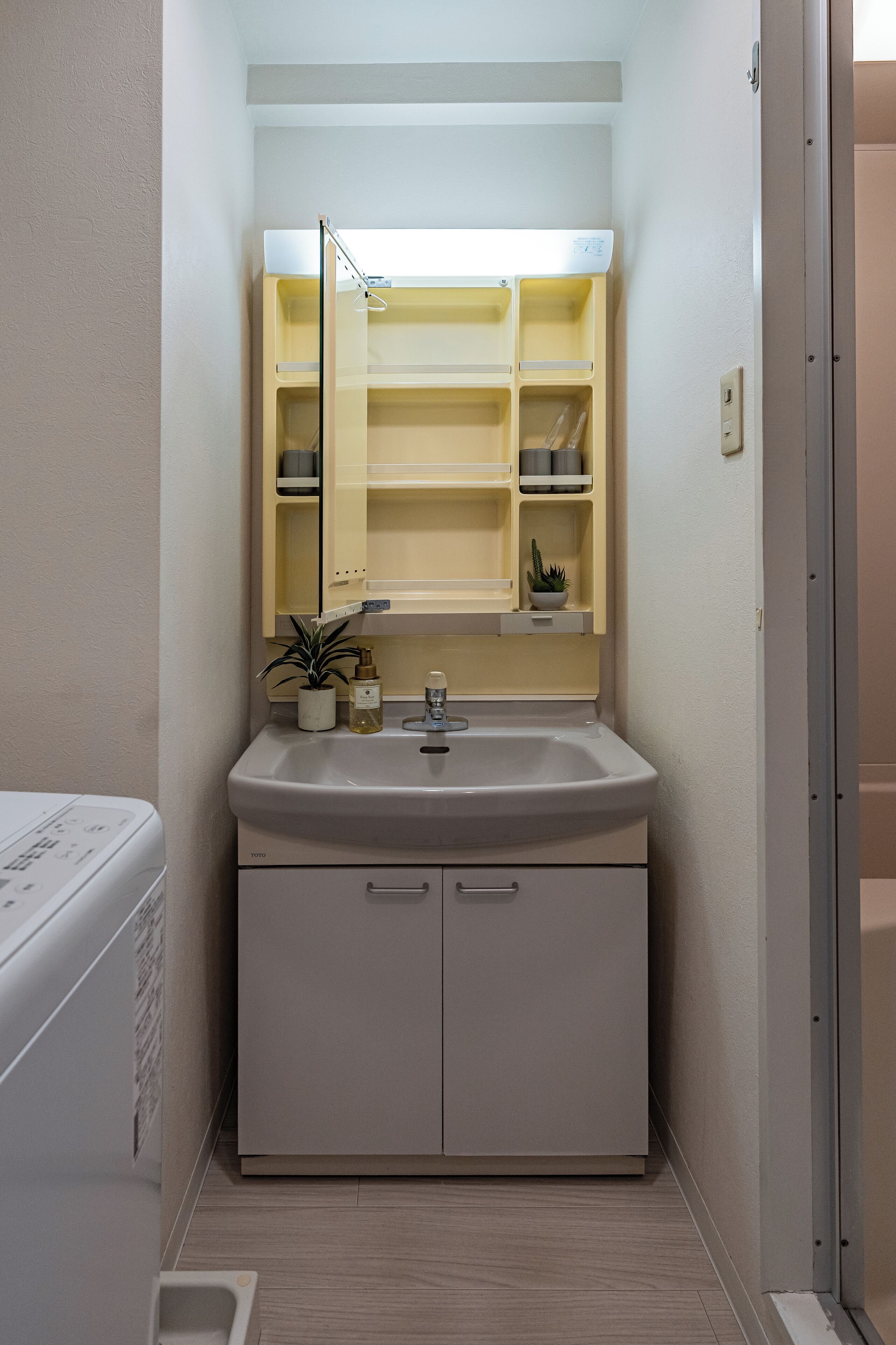 A bathroom with a sink, mirror, and storage cabinets.