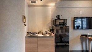 Eine moderne Küche mit einem schwarzen Kühlschrank, einer Mikrowelle und einem Spülbecken.