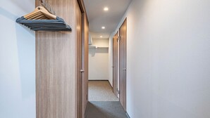 Ein Flur mit einer Holzwand, einem Kleiderständer und einem Teppichboden.